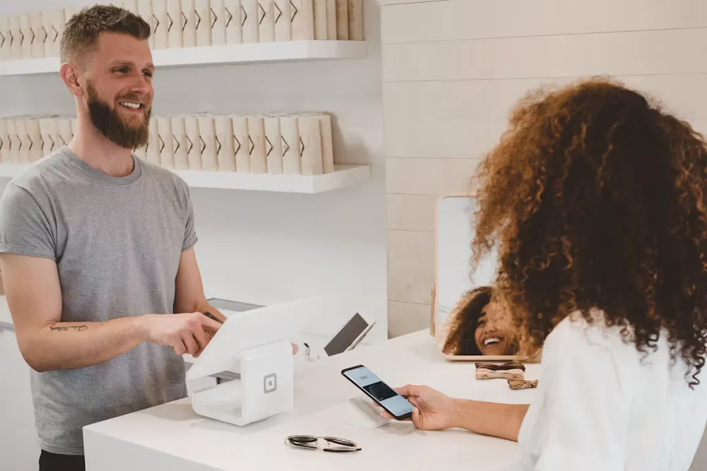 Staff serving a customer at a shop counter